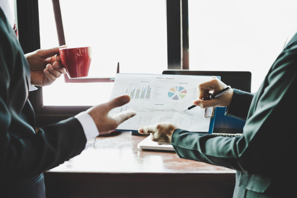 Alt Text Business professionals collaborating in a modern office while reviewing marketing analytics, customer insights, campaign performance metrics, and business growth data on a large digital dashboard.